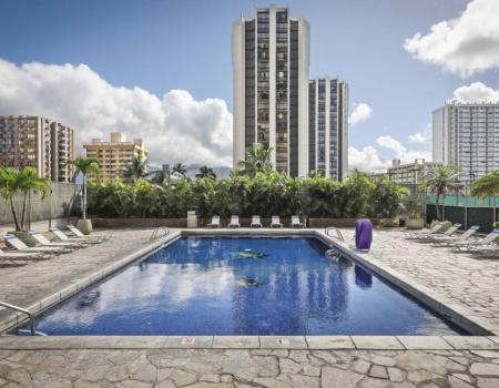 Pool chairs surrounding communal pool at Aston Waikiki Sunset resort