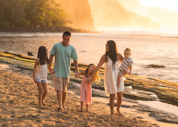 family walking on beach at sunset in maui