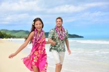 Fun couple on beach vacations in Hawaiian clothing.