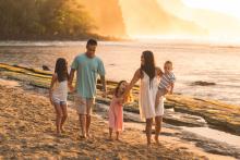 family walking on beach at sunset in maui