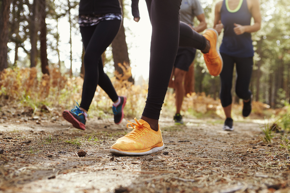 runner's feet jogging on a trail